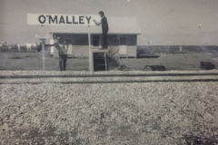 John Flaherty   with his hand on the sign and 'Peter from Colac near Melbourne', unknown surname, is on the left leaning on the post.